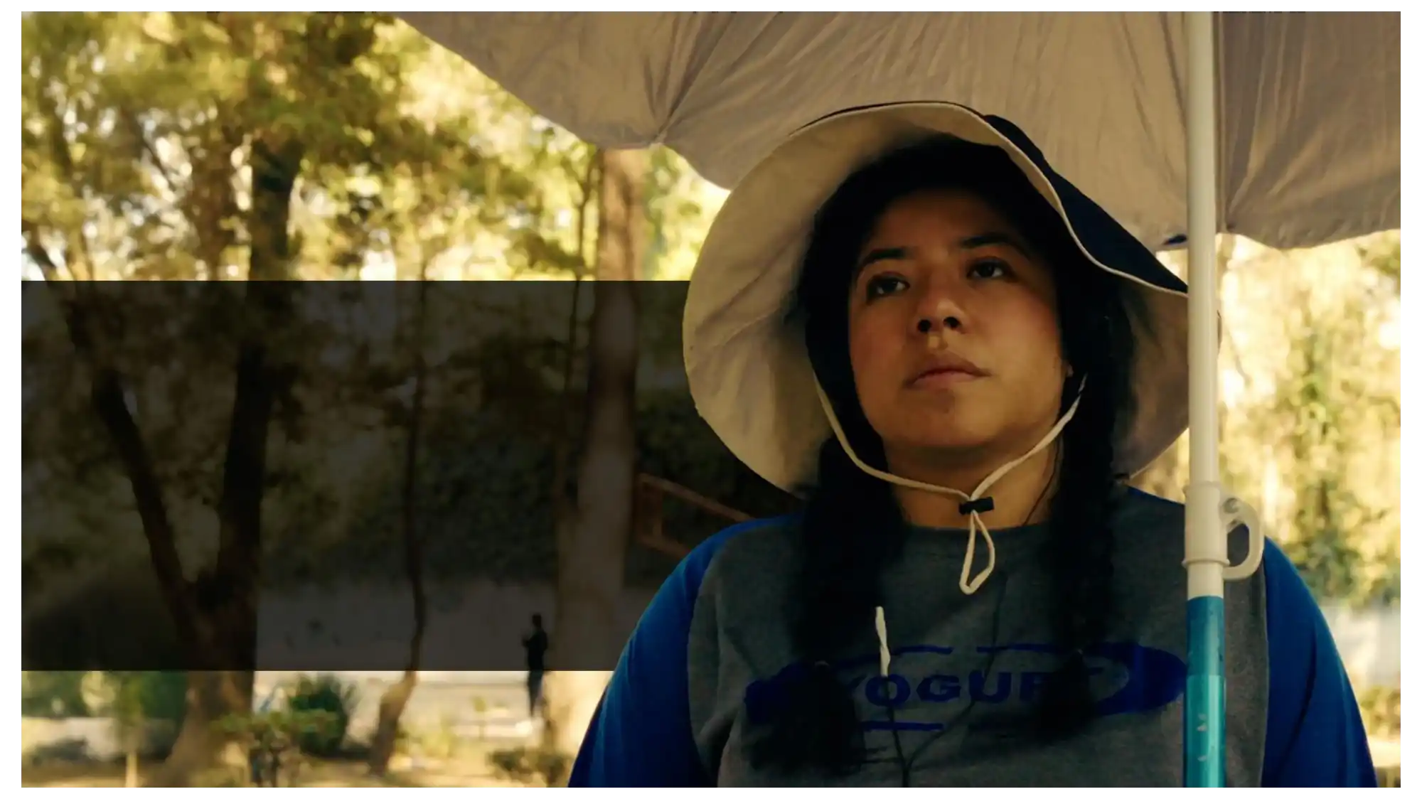Mika, humana voluntaria, con sombrero de ala ancha en una distribución al aire libre.